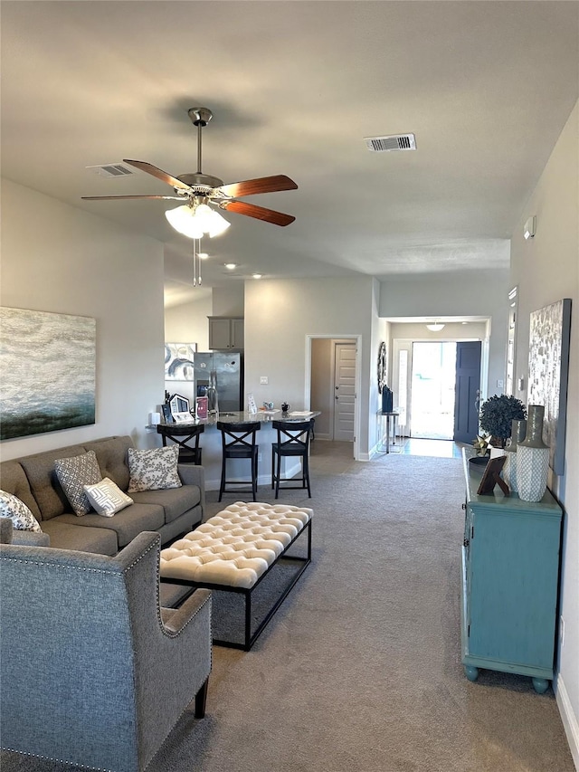 carpeted living area featuring visible vents, baseboards, and ceiling fan