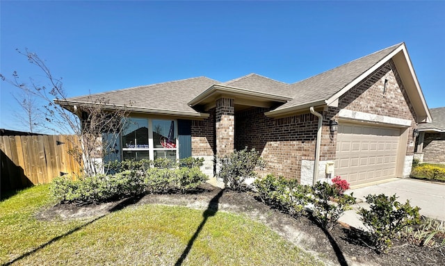 view of front of property with fence, roof with shingles, an attached garage, concrete driveway, and brick siding