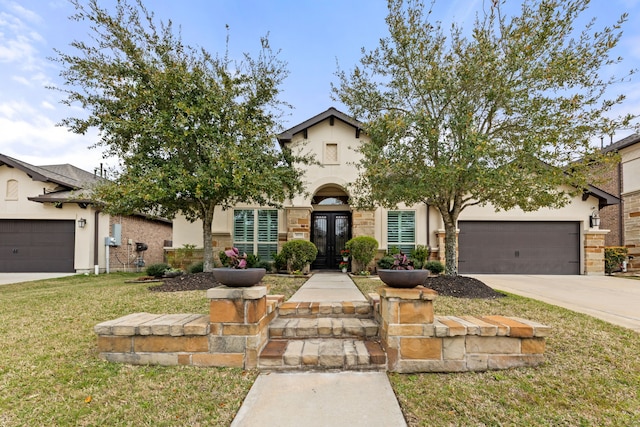 view of front of home featuring french doors, an attached garage, driveway, and stucco siding