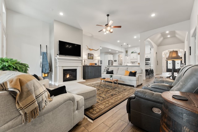 living room featuring arched walkways, recessed lighting, a ceiling fan, and wood tiled floor