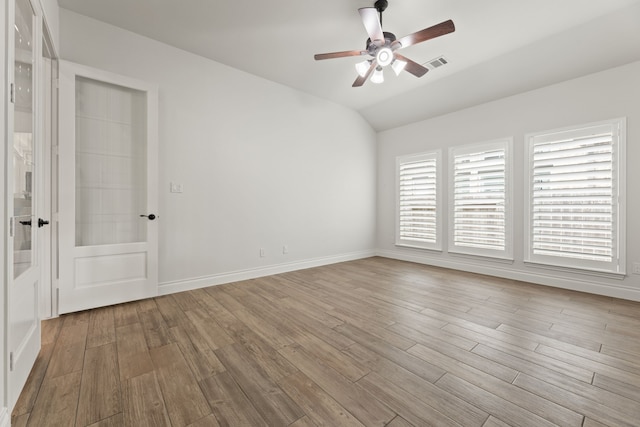 unfurnished room with visible vents, wood finished floors, baseboards, ceiling fan, and vaulted ceiling