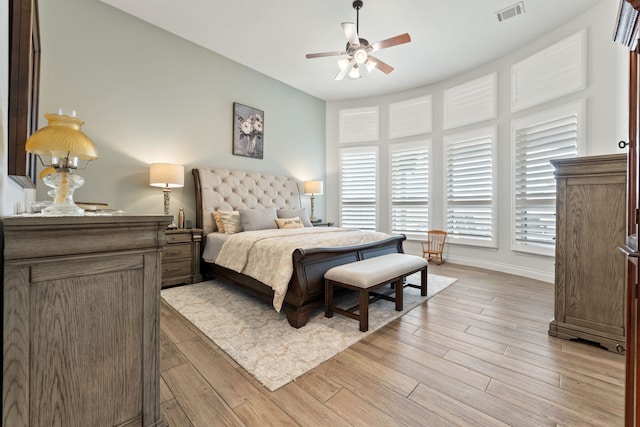 bedroom with visible vents, baseboards, light wood-style floors, and a ceiling fan