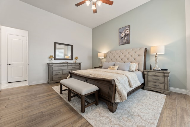 bedroom featuring baseboards, a ceiling fan, and light wood finished floors