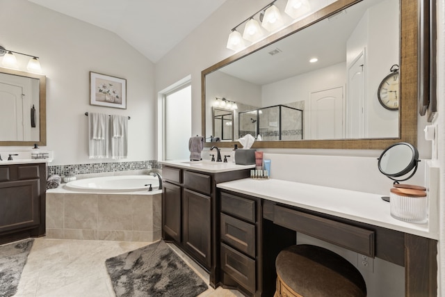 bathroom with two vanities, a stall shower, a sink, vaulted ceiling, and a garden tub