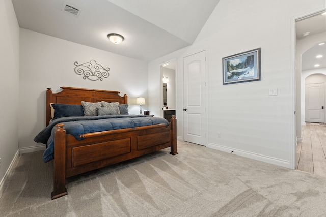 bedroom with visible vents, arched walkways, carpet, baseboards, and vaulted ceiling