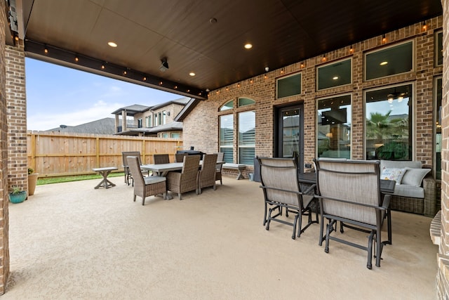 view of patio with outdoor dining space and fence