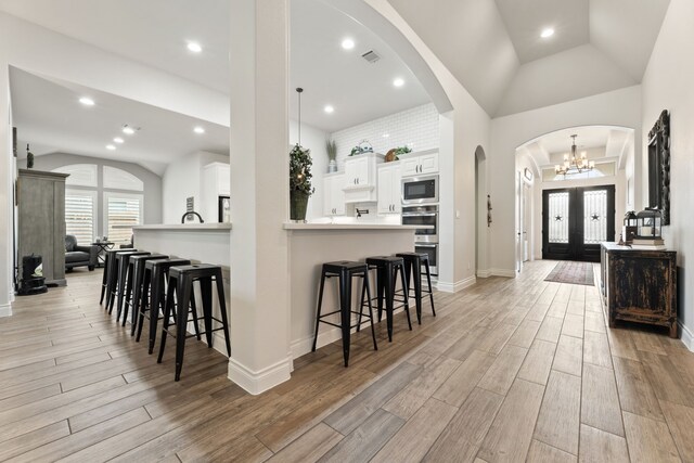 entrance foyer featuring visible vents, recessed lighting, arched walkways, baseboards, and wood tiled floor