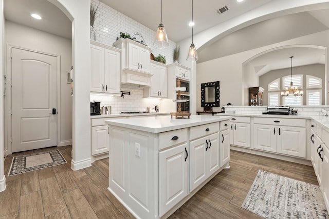 kitchen featuring a chandelier, visible vents, light wood finished floors, and a kitchen island