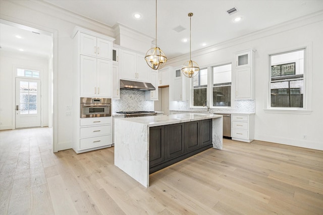7527 Ciano Ln, Houston, TX 77055 - kitchen with appliances with stainless steel finishes, ornamental molding, under cabinet range hood, white cabinetry, and backsplash