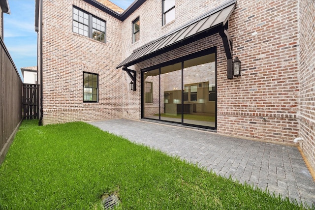 7527 Ciano Ln, Houston, TX 77055 - back of house with a standing seam roof, brick siding, metal roof, and a patio area