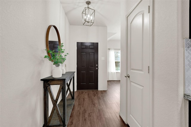 foyer with a notable chandelier and wood finished floors