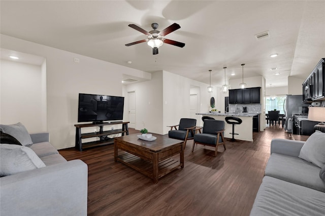 living area featuring visible vents, dark wood-type flooring, baseboards, recessed lighting, and a ceiling fan