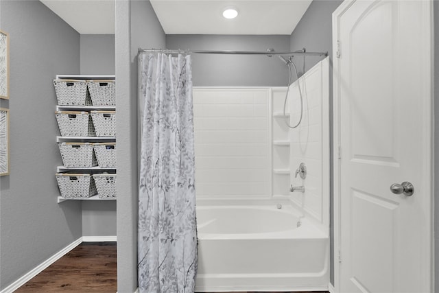 full bathroom with shower / tub combo, baseboards, and wood finished floors