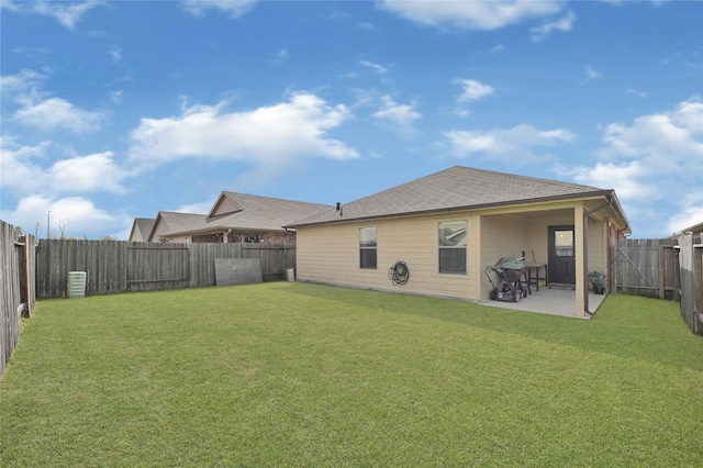 rear view of property featuring a fenced backyard, a lawn, and a patio