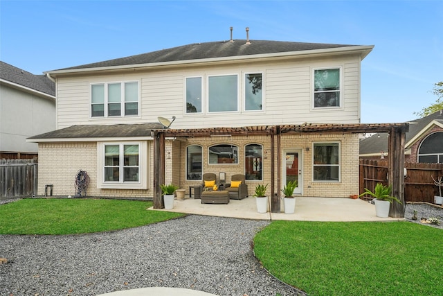 rear view of house with brick siding, a patio area, a lawn, and fence