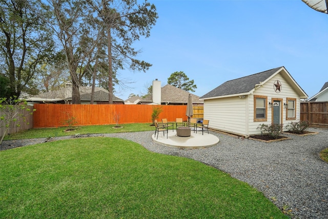 view of yard with a patio, an outdoor structure, a fire pit, and a fenced backyard