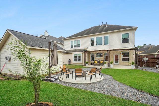 back of property with brick siding, a lawn, a patio, and fence