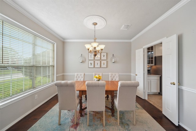 dining space with crown molding, dark wood-style floors, visible vents, and a chandelier