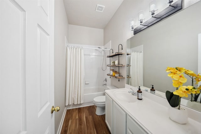 bathroom featuring visible vents, toilet, shower / tub combo with curtain, wood finished floors, and vanity