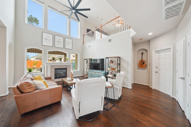 living room with dark wood finished floors, visible vents, a fireplace, and baseboards