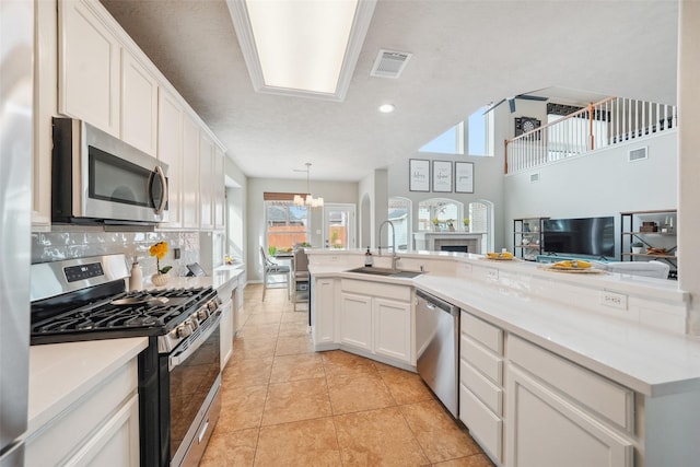 kitchen featuring visible vents, white cabinets, stainless steel appliances, and a sink