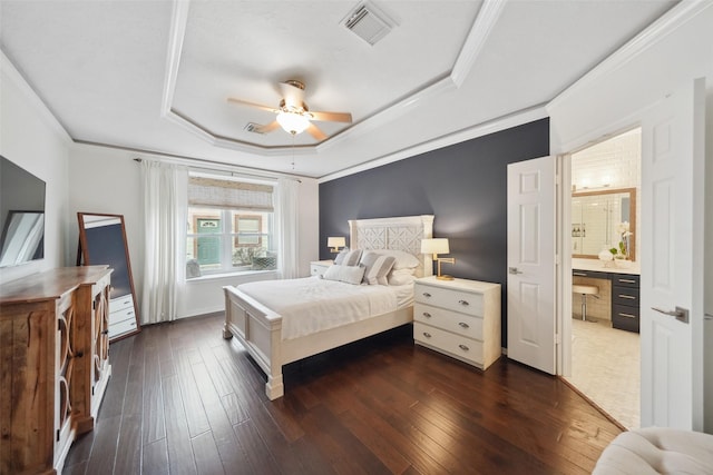 bedroom featuring a tray ceiling, dark wood-type flooring, visible vents, and ornamental molding