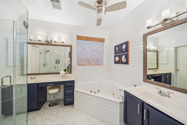 full bathroom featuring visible vents, ceiling fan, a stall shower, tile walls, and a sink