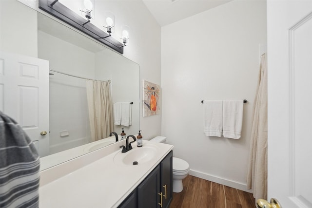 bathroom with a shower with curtain, toilet, wood finished floors, baseboards, and vanity