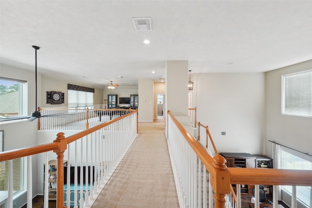 hall with recessed lighting, visible vents, light colored carpet, and an upstairs landing