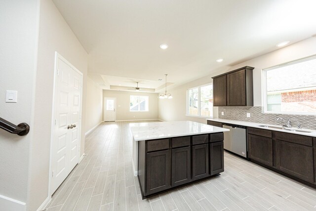 3714 Windswept Dr, Montgomery, TX 77356 - kitchen with stainless steel dishwasher, a sink, dark brown cabinetry, light wood-style flooring, and a kitchen island