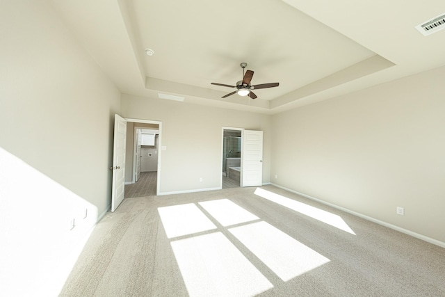 3714 Windswept Dr, Montgomery, TX 77356 - unfurnished bedroom featuring a tray ceiling, a walk in closet, visible vents, and light carpet