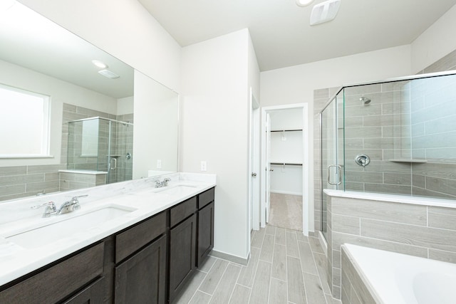 3714 Windswept Dr, Montgomery, TX 77356 - full bathroom featuring a walk in closet, double vanity, a shower stall, and a sink