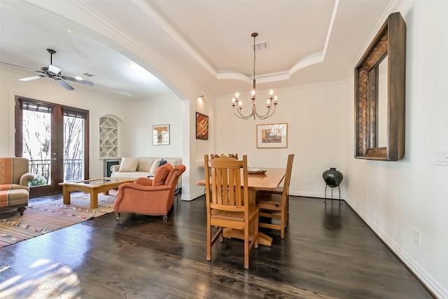 4303 Blossom St, Houston, TX 77007 - dining area with dark wood-style flooring, a chandelier, ceiling fan, ornamental molding, and arched walkways
