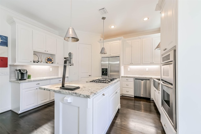 4303 Blossom St, Houston, TX 77007 - kitchen featuring stainless steel appliances, backsplash, white cabinetry, a kitchen island, and dark wood-style flooring