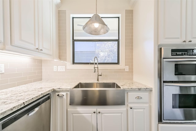 4303 Blossom St, Houston, TX 77007 - kitchen with appliances with stainless steel finishes, a sink, tasteful backsplash, and white cabinetry
