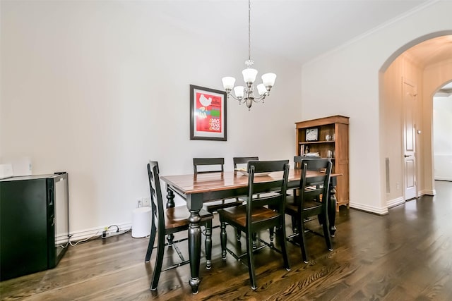 4303 Blossom St, Houston, TX 77007 - dining area with arched walkways, dark wood finished floors, ornamental molding, a chandelier, and baseboards