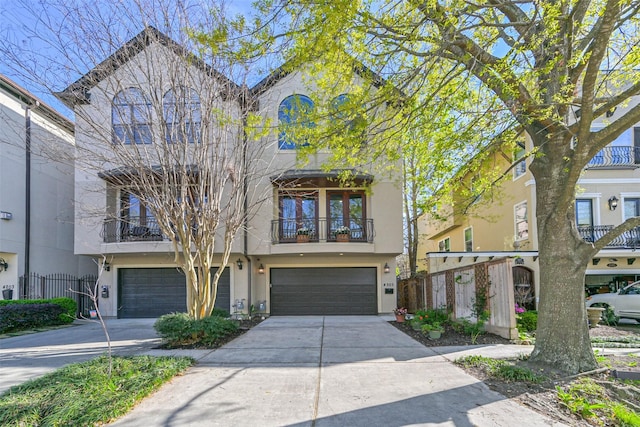 4303 Blossom St, Houston, TX 77007 - view of property featuring stucco siding, a garage, concrete driveway, and a balcony