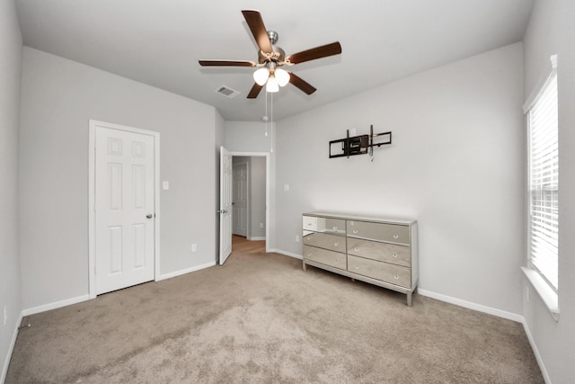 unfurnished bedroom with carpet flooring, ceiling fan, visible vents, and baseboards