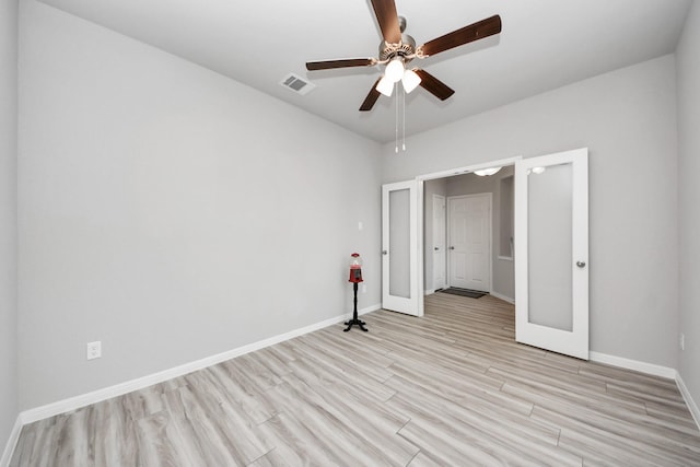 unfurnished bedroom featuring visible vents, baseboards, ceiling fan, light wood-style flooring, and french doors