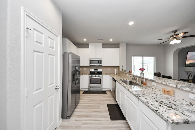 kitchen featuring visible vents, a sink, white cabinetry, appliances with stainless steel finishes, and a peninsula