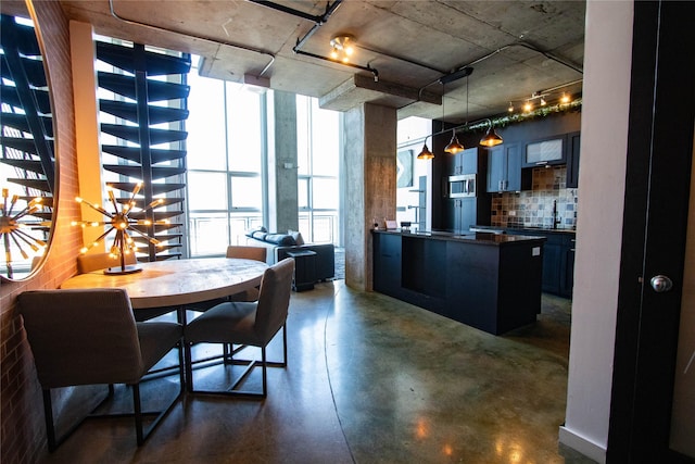 dining space featuring a wall of windows and concrete floors