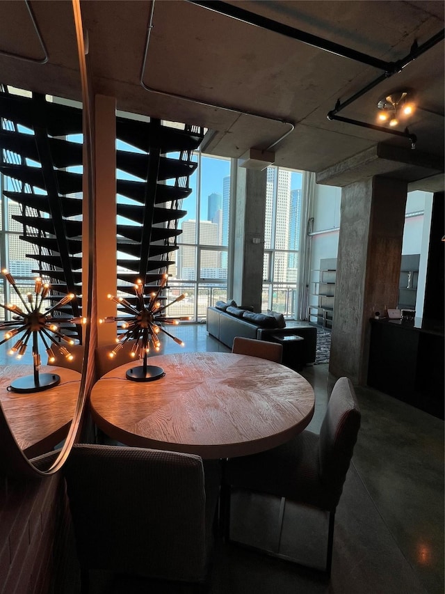 dining area with a city view and a wall of windows