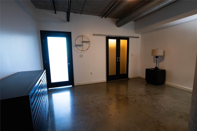 interior space featuring french doors, baseboards, and finished concrete flooring