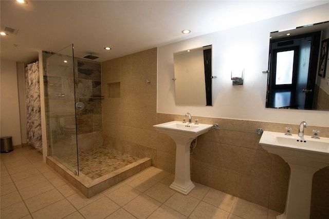 full bath featuring tile patterned flooring, recessed lighting, a shower stall, and tile walls