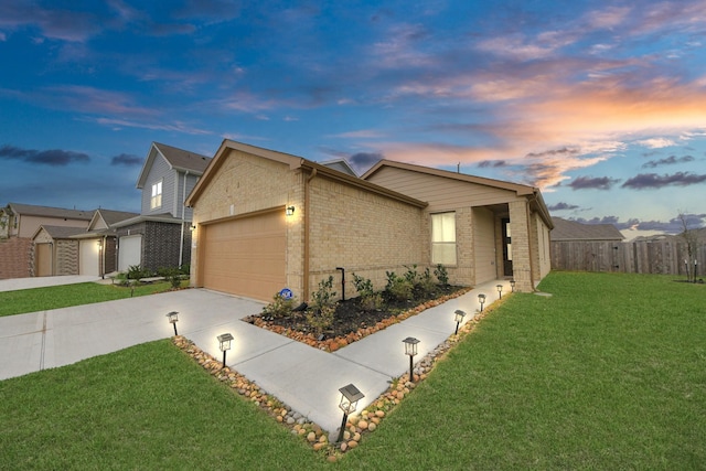 view of home's exterior with fence, a yard, concrete driveway, a garage, and brick siding