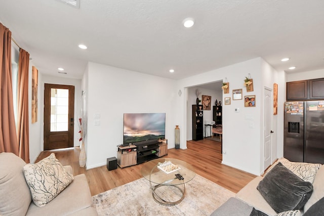 living room with recessed lighting, light wood-style floors, and baseboards