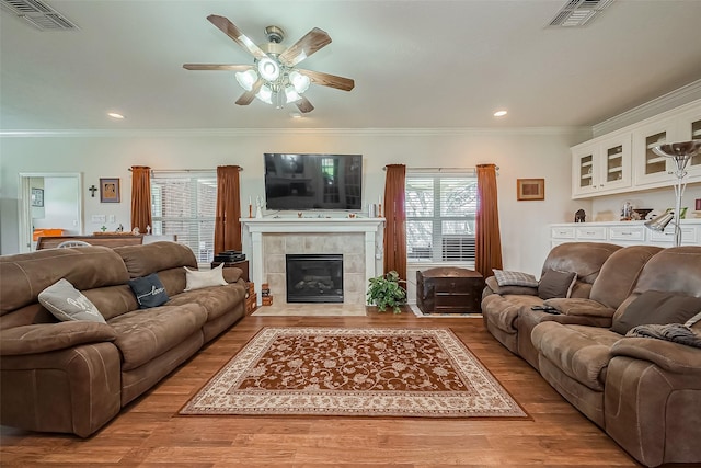 living area with visible vents, wood finished floors, and a ceiling fan