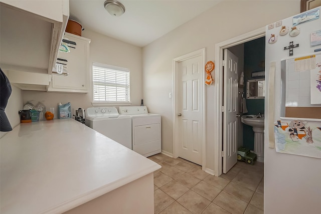 clothes washing area featuring independent washer and dryer, light tile patterned flooring, and laundry area