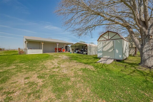 view of yard featuring a storage shed, a detached carport, and an outbuilding