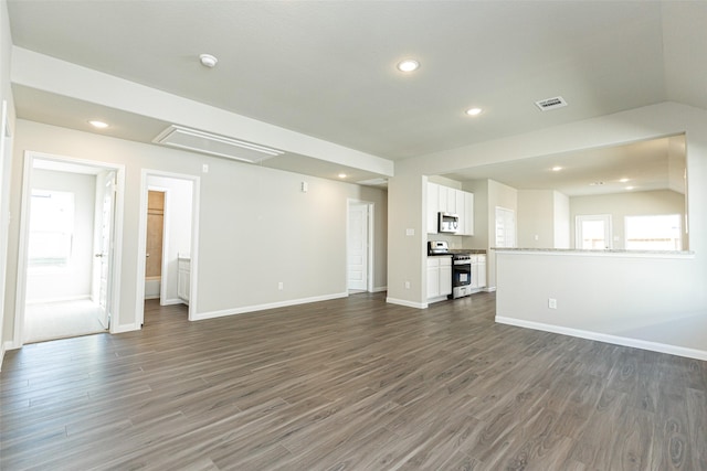 unfurnished living room with dark wood-style floors, visible vents, baseboards, attic access, and recessed lighting